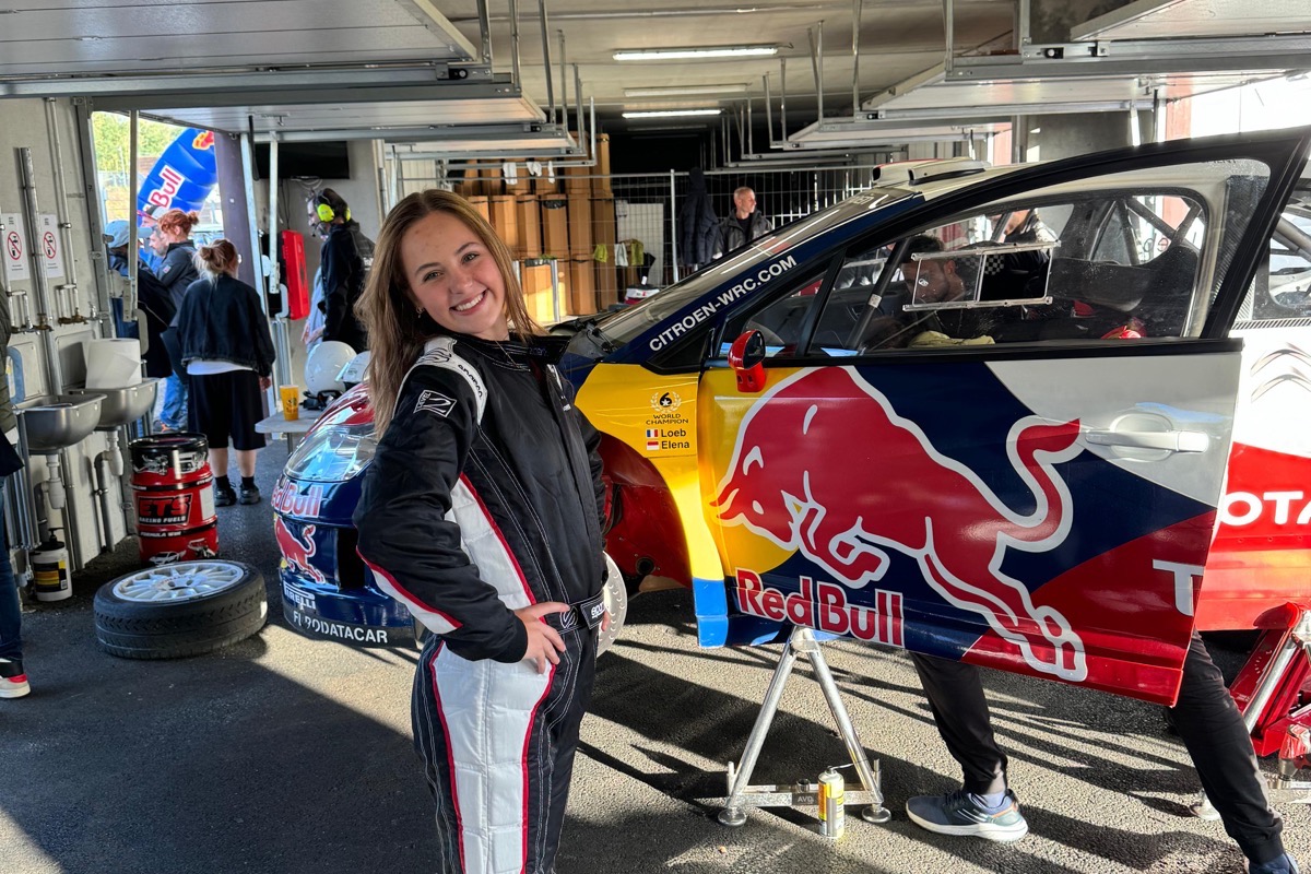 Créatrice VY Media en combinaison de pilote devant la Citroën C4 WRC aux couleurs Red Bull de Sébastien Loeb, dans les stands de l'Anneau du Rhin